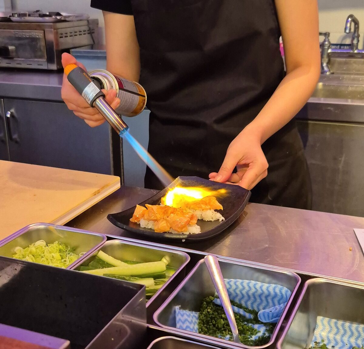 Blowtorching burnt salmon at Kumori handroll restaurant review Soho, London